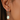 woman wearing Black gold-leafed green amethyst drop earrings, gold statement earrings with beige blouse